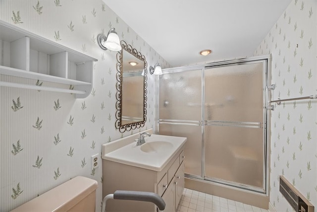 bathroom featuring tile patterned flooring, vanity, toilet, and a shower with door