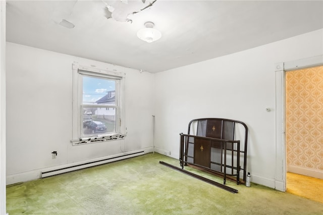 carpeted spare room featuring a baseboard heating unit