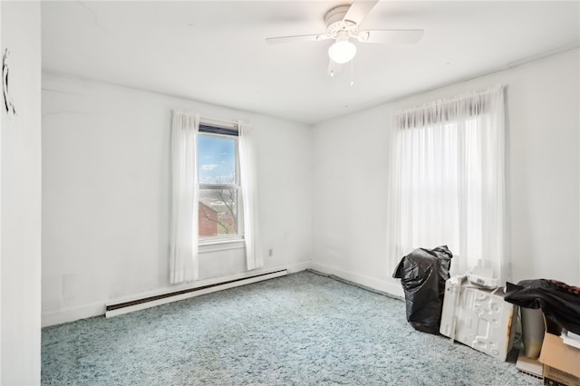 carpeted empty room featuring baseboard heating and ceiling fan