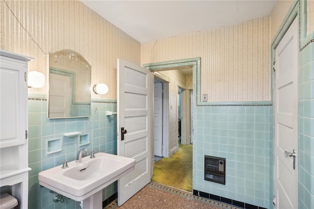 bathroom featuring tile walls and sink