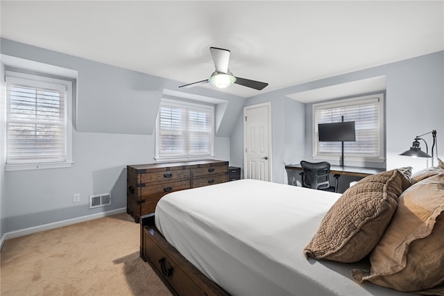 bedroom featuring multiple windows, light colored carpet, and ceiling fan