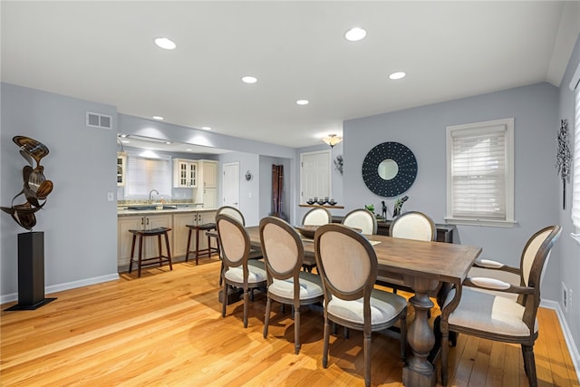 dining area with light hardwood / wood-style flooring and sink