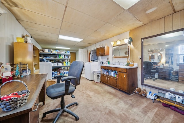 carpeted home office featuring a paneled ceiling and wooden walls