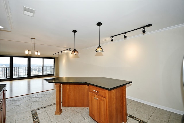 kitchen with pendant lighting, rail lighting, light tile patterned floors, a kitchen island, and a breakfast bar area