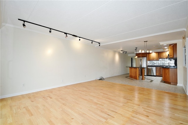 unfurnished living room with light hardwood / wood-style flooring, rail lighting, and ornamental molding