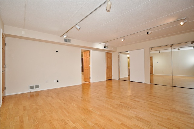 unfurnished room featuring a textured ceiling and light hardwood / wood-style floors