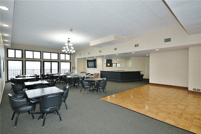 dining area with carpet flooring and an inviting chandelier