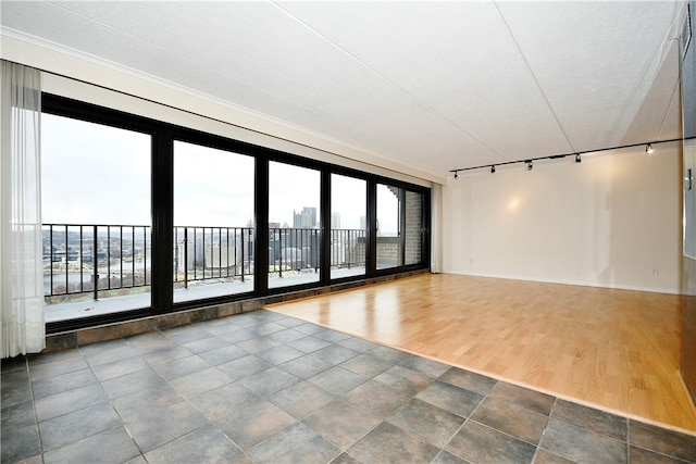 unfurnished room featuring wood-type flooring, rail lighting, and a textured ceiling