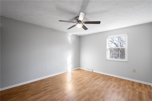 spare room featuring a textured ceiling, ceiling fan, ornamental molding, and light hardwood / wood-style floors