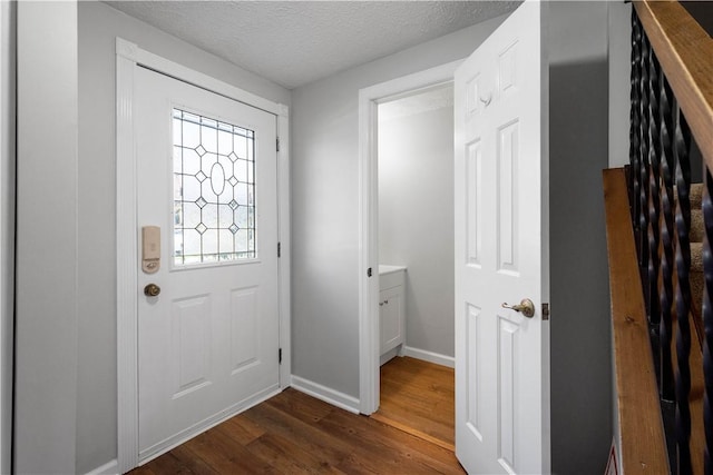 doorway to outside featuring dark wood-type flooring and a textured ceiling