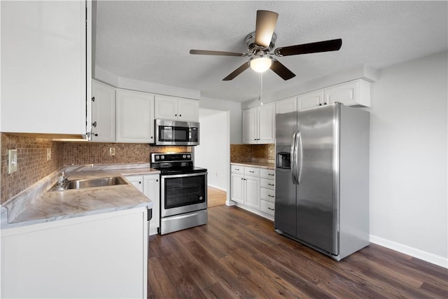 kitchen featuring tasteful backsplash, dark hardwood / wood-style floors, sink, appliances with stainless steel finishes, and white cabinets