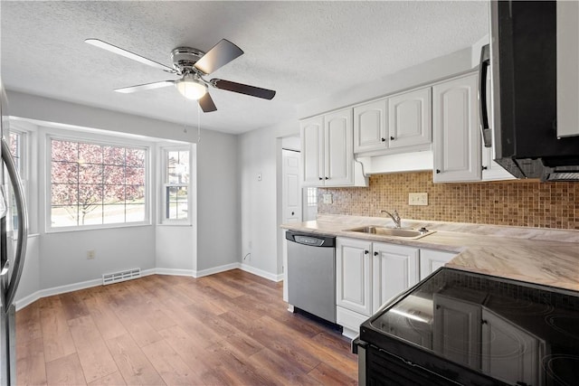 kitchen featuring white cabinets, stainless steel dishwasher, sink, and black electric range