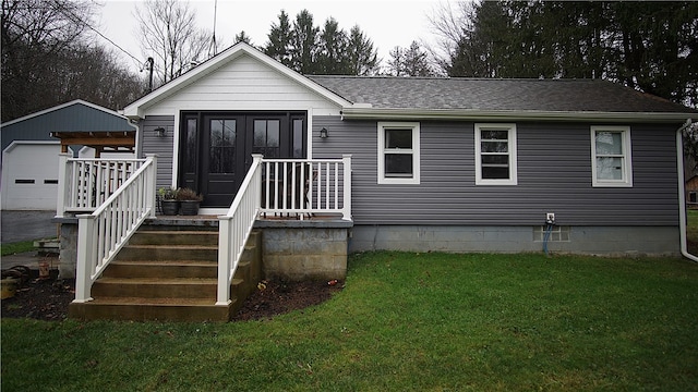 view of front of house featuring a garage, a front lawn, and an outdoor structure