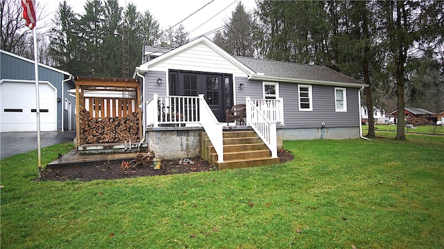 view of front of home with a front yard, an outdoor structure, and a garage