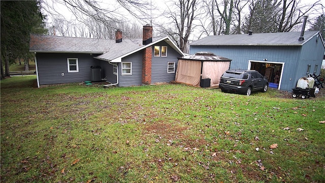 back of house featuring a yard and central AC