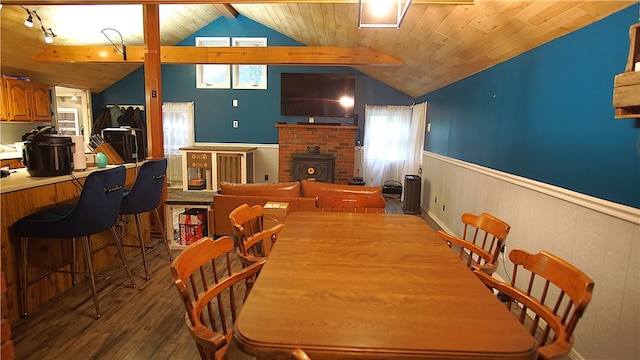 dining area with a wood stove, wooden ceiling, dark wood-type flooring, and vaulted ceiling with beams