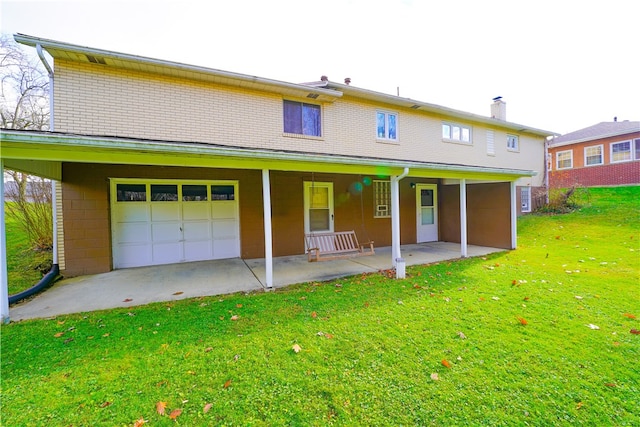 back of house featuring a lawn, covered porch, and a garage