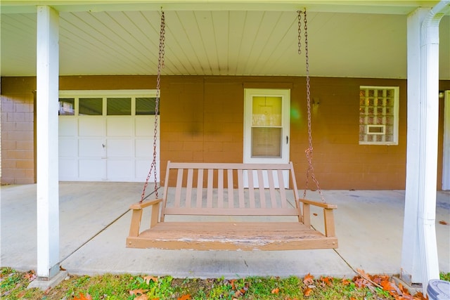 view of exterior entry with a garage and covered porch