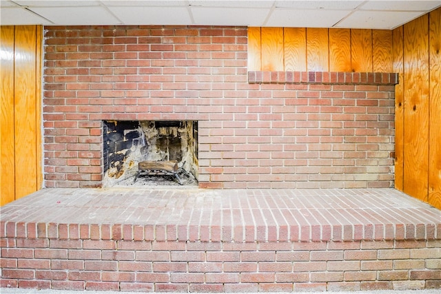 details featuring wooden walls and a brick fireplace