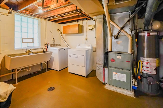 basement with heating unit, washing machine and clothes dryer, sink, and water heater