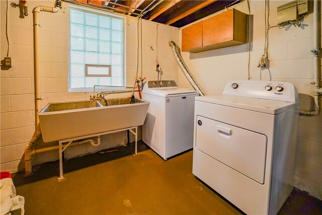 clothes washing area with plenty of natural light, washing machine and dryer, and sink