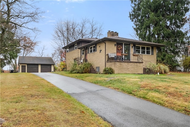 view of front of house featuring a front yard, a garage, and an outdoor structure