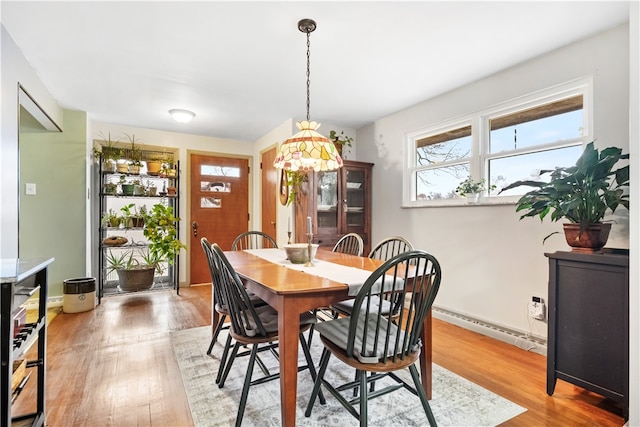 dining space with hardwood / wood-style flooring and baseboard heating