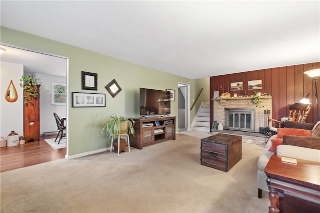 carpeted living room with a brick fireplace and wood walls