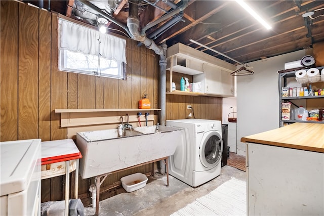 laundry area featuring wood walls and cabinets