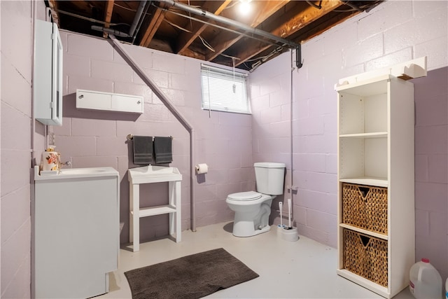 bathroom featuring concrete flooring, toilet, and sink