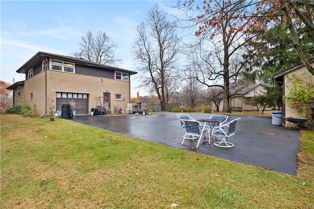 rear view of house featuring a yard and a garage