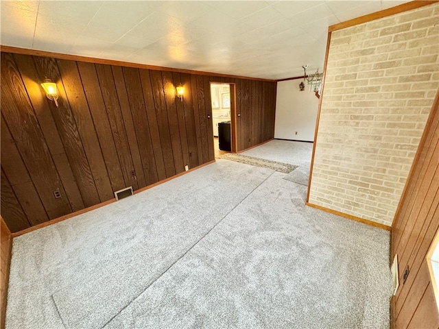 spare room with light carpet and wooden walls