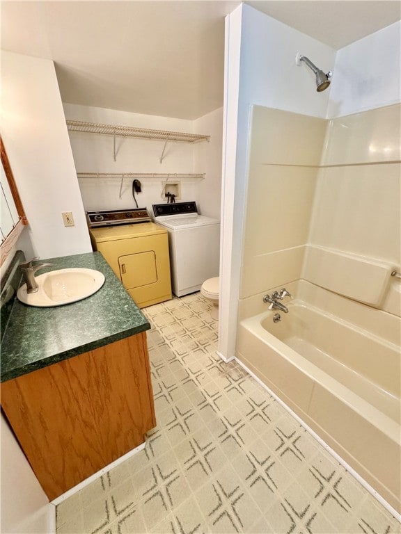 full bathroom featuring vanity, toilet, washing machine and dryer, and tub / shower combination