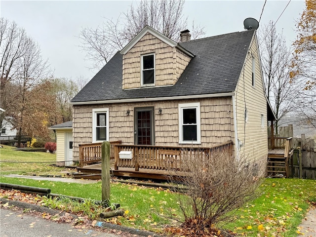 view of front of home with a wooden deck and a front yard