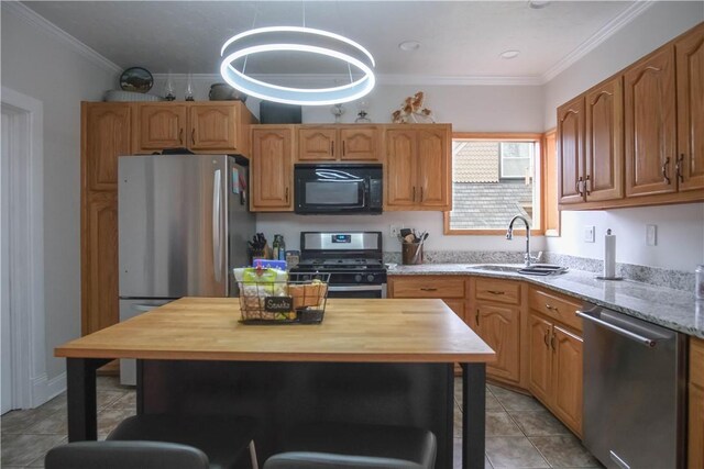 kitchen with light stone countertops, crown molding, sink, and black appliances