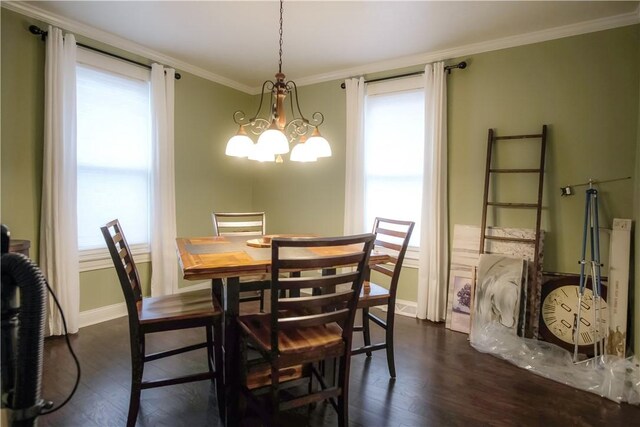 dining room featuring dark hardwood / wood-style flooring, crown molding, and a chandelier