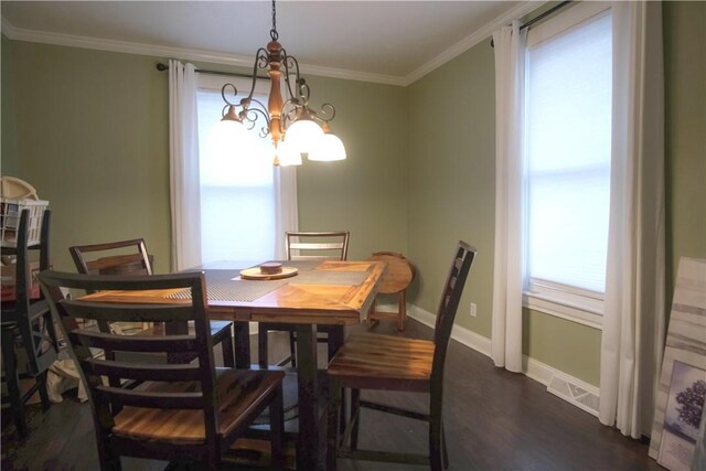 dining area with dark hardwood / wood-style floors, crown molding, and a notable chandelier