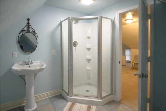 bathroom with tile patterned flooring, a shower with door, and lofted ceiling