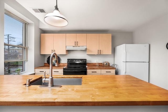 kitchen with wooden counters, light brown cabinets, white refrigerator, black electric range, and hanging light fixtures