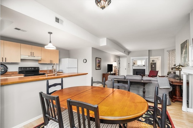 dining room featuring sink and light hardwood / wood-style flooring