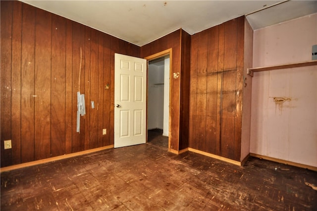 unfurnished bedroom featuring wooden walls