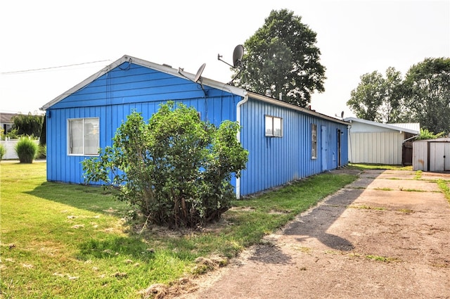 view of home's exterior with a yard and a storage shed