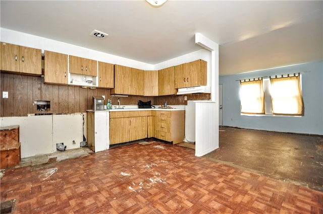 kitchen featuring dark parquet flooring, wooden walls, and range hood