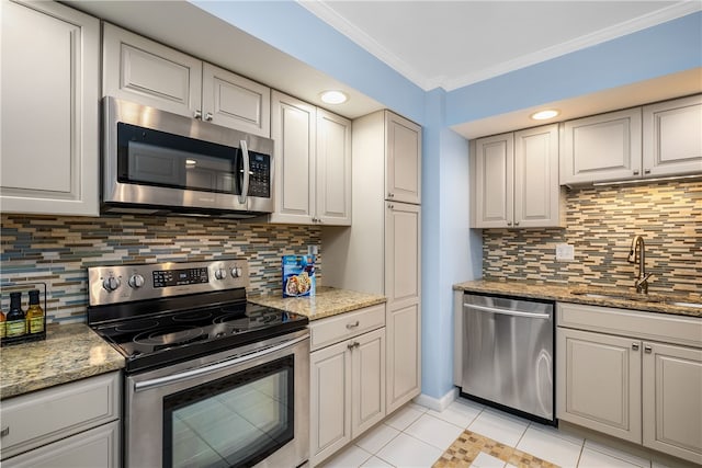 kitchen featuring backsplash, ornamental molding, stainless steel appliances, sink, and light tile patterned floors