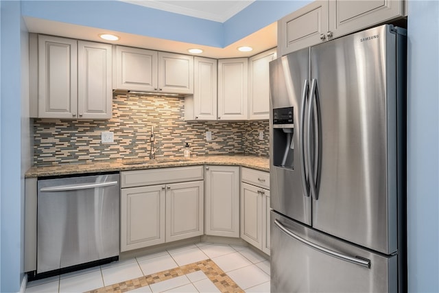 kitchen featuring light stone countertops, sink, light tile patterned floors, and appliances with stainless steel finishes