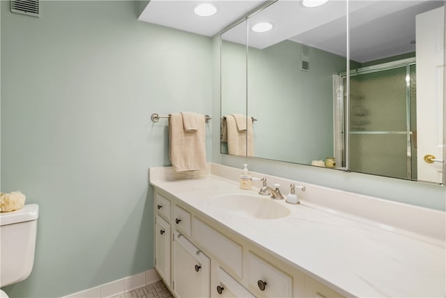 bathroom featuring tile patterned floors, vanity, toilet, and walk in shower