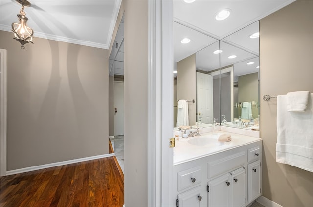 bathroom with vanity, wood-type flooring, and ornamental molding