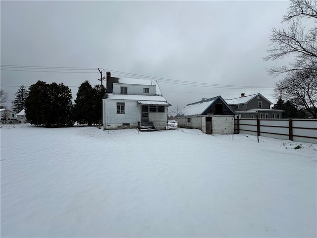 view of snow covered back of property