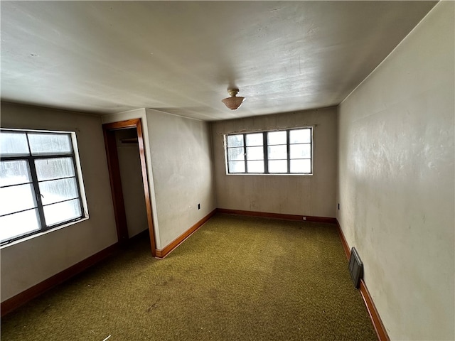 spare room featuring carpet flooring and plenty of natural light