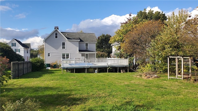 rear view of house featuring a deck and a yard